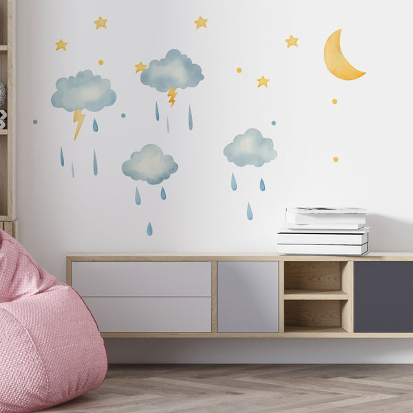 Watercolor cloud wall decals with rain, lightning, moon, and stars on a white wall in a modern nursery room