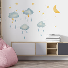 Watercolor cloud wall decals with rain, lightning, moon, and stars on a white wall in a modern nursery room