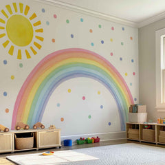 Large watercolor wall decal featuring a pastel rainbow arch, a large yellow sun, and colorful polka dots in a bright, modern nursery and playroom.